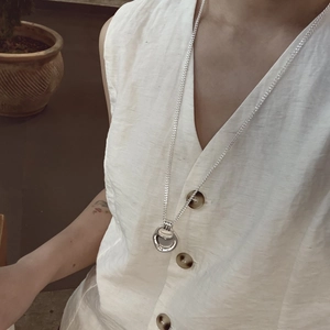 Minimalist silver long necklace with circular open ring pendant worn on white vest
