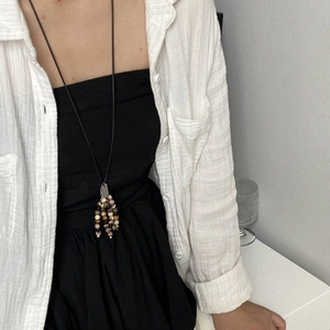 Retro natural stone beaded tassel long necklace on model with minimalist black and white outfit