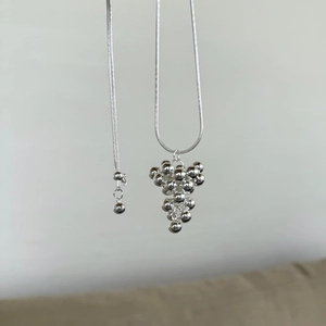 Detailed shot of polished silver spherical grape cluster pendant with smooth snake chain