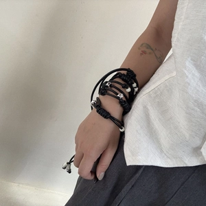 Handcrafted multi-layered black cord bracelet with silver geometric beads and tassels