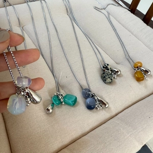 Detail showing various natural stone grape pendants on fine silver titanium steel chains