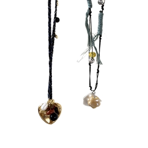 Handmade woven cord necklace featuring vintage heart pendant and natural stone details