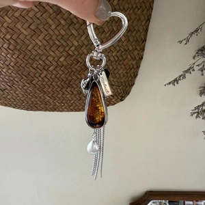 Maillard waterdrop pendant necklace with heart clasp, amber resin, and tassels detail