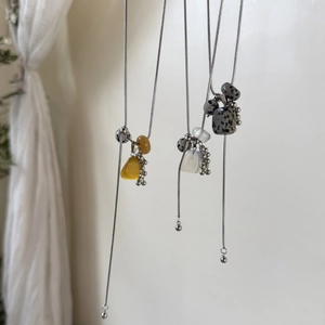Macro detail of titanium steel necklace with natural stones and grape cluster beads