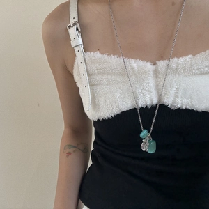 Detailed view of long titanium steel necklace with natural stone grape charm on model