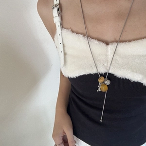 Detail of long necklace with natural stone beads and silver chain on a model