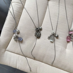 Macro view of four grape-style natural stone pendants on titanium steel snake chains