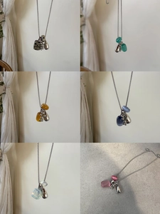 Macro detail of natural stone pendants and silver chain of this multi-color grape necklace