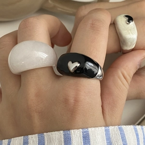 Détail de bagues en résine colorées avec motifs de cœur et textures blanc translucide