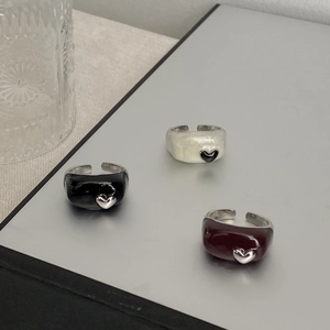Vue détaillée de trois bagues cœur en émail de couleur noir, crème et rouge foncé