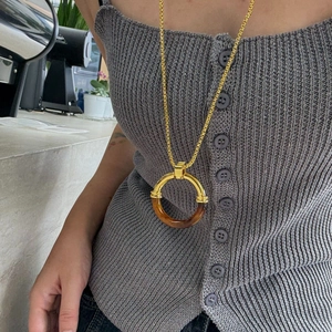 Minimalist stainless steel necklace featuring amber resin rings on long gold chain
