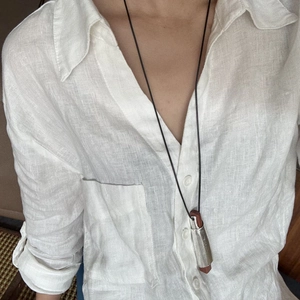 Collana minimalista con ciondolo in legno e metallo a forma di rotolo e corda nera