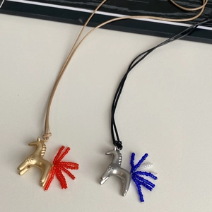Dettaglio di collane con ciondolo a forma di cavallo in oro e argento con nappine di perle