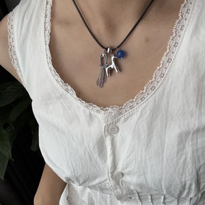 Elegante collana con ciondolo a pony in argento, perla blu e nappa su cordino nero