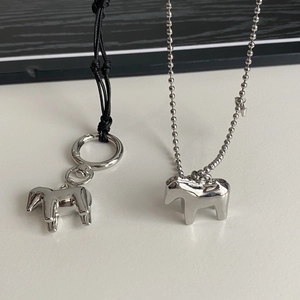 Dettaglio di ciondoli a forma di cavallo in argento con catena a sfere e cordino
