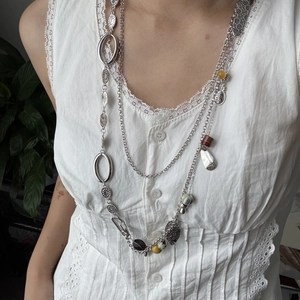 Detalle del collar multicapa bohemio vintage con cadenas plateadas y cuentas de piedra