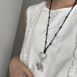 Dettaglio della collana con ciondolo a cavallo d'argento su cordino nero lungo