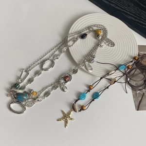 Detalle de collar multicapa con cuentas turquesas y colgante de estrella de mar