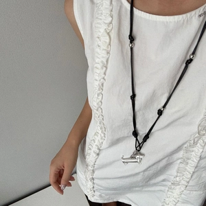 Silver dachshund puppy pendant on a black cord necklace with metallic bead details