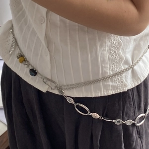 Detalle de cadena de cuerpo estilo vintage con plumas y cuentas de piedra natural en modelo