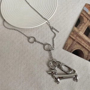 Detail view of silver dachshund pendant on a spliced chain with a numeric tag