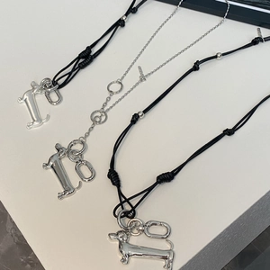 Detailed view of silver dachshund pendants with black cord and beaded chain necklaces