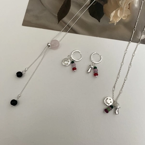 Detailansicht eines Silber-Schmucksets mit bunten Perlen und kleinen Pilzanhängern