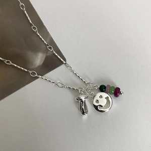 Detailaufnahme der Silberkette mit Pilzanhänger, Smiley-Gesicht und bunten Perlen