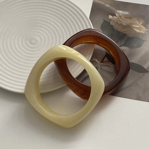 Macro shot of thick square resin bangles in cream yellow and amber tortoiseshell patterns