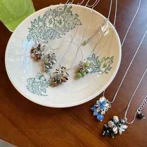 Detailed collection of silver flower necklaces with multi-colored natural stone charms