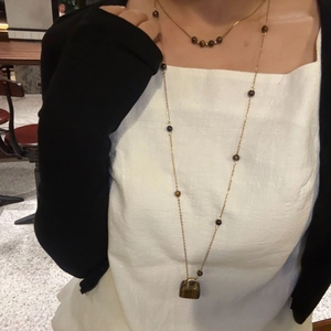 Mehrlagige Goldhalskette mit dunklen Tigeraugen-Perlen und einem Mini-Taschen-Anhänger