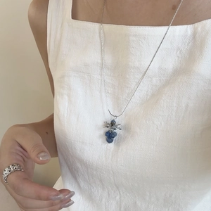 Silver necklace with grape cluster pendant featuring translucent blue stones and leaves