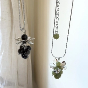 Detailed view of handmade beaded grape cluster pendant necklaces in green and black colors