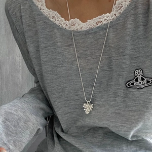 Primer plano de un colgante de piña plateada en cordón negro ajustable para mujer