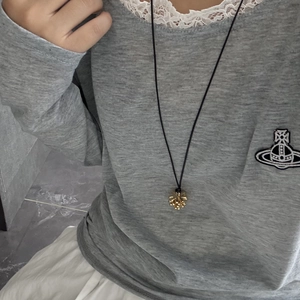 Primer plano del colgante de racimo dorado con collar de cordón negro ajustable elegante