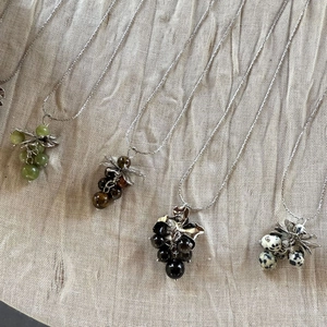 Detail of colorful natural stone grape cluster pendants with silver metal leaf charms