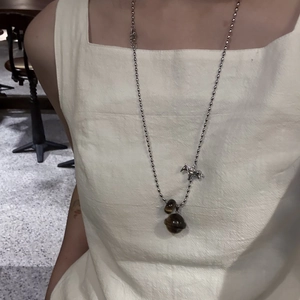 Dettaglio della collana in acciaio al titanio argento con cavallo e pietra occhio di tigre