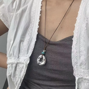 Boho ασημί σφυρήλατο κολιέ με τυρκουάζ χάντρα πάνω σε λευκή δαντελένια ζακέτα