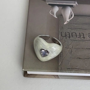 Detailed shot of an adjustable heart ring with marble enamel and inlaid zircon