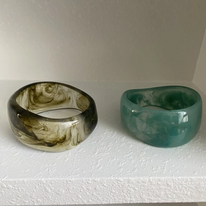 Detailed shot of irregular resin bangles with ink-black and blue marble textures