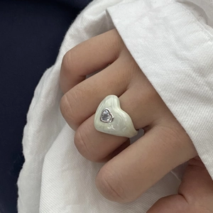 Green marble enamel heart ring with center zircon worn by a hand with white shirt