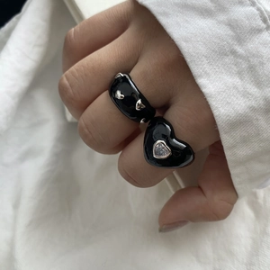Set of black enamel rings featuring silver heart accents and a large zircon heart stone