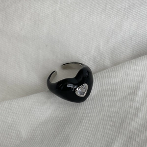 Detailed top view of a black enamel heart-shaped ring with a sparkling zircon inlay