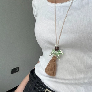 Ethnic zebra pendant necklace with beads and brown tassels on a cream woven cord