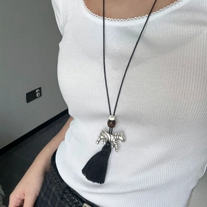 Close-up of zebra pendant long necklace with ethnic tassel and brown bead detail