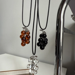 Minimalist grape cluster pendant necklace on black cord in brown black and clear resin