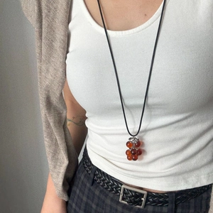 Minimalist long black cord necklace with amber grape cluster pendant on model