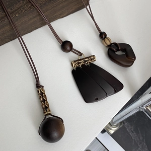 Detailed view of bohemian style brown necklaces with wood beads and bronze metal accents