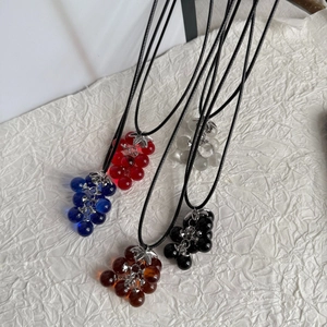 Detail view of five grape cluster necklaces in red blue clear black and brown resin beads