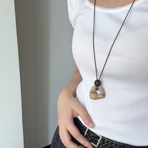 Detail of vintage long necklace with natural textured stone and brown wood bead